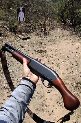 Short pump shotgun with a bird-head grip and sling at the range